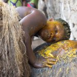 A Koku adherent pays homage to the spirits at a legba (image by Inger Vandyke)