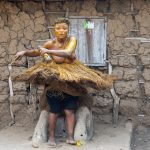 A female Koku dancer twirling in front of the Legba devoted to Koku spirits. A Legba is like a shrine for offerings to certain gods (image by Inger Vandyke)