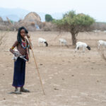 A young Arbore girl carries a goat kid back to her village (image by Inger Vandyke)