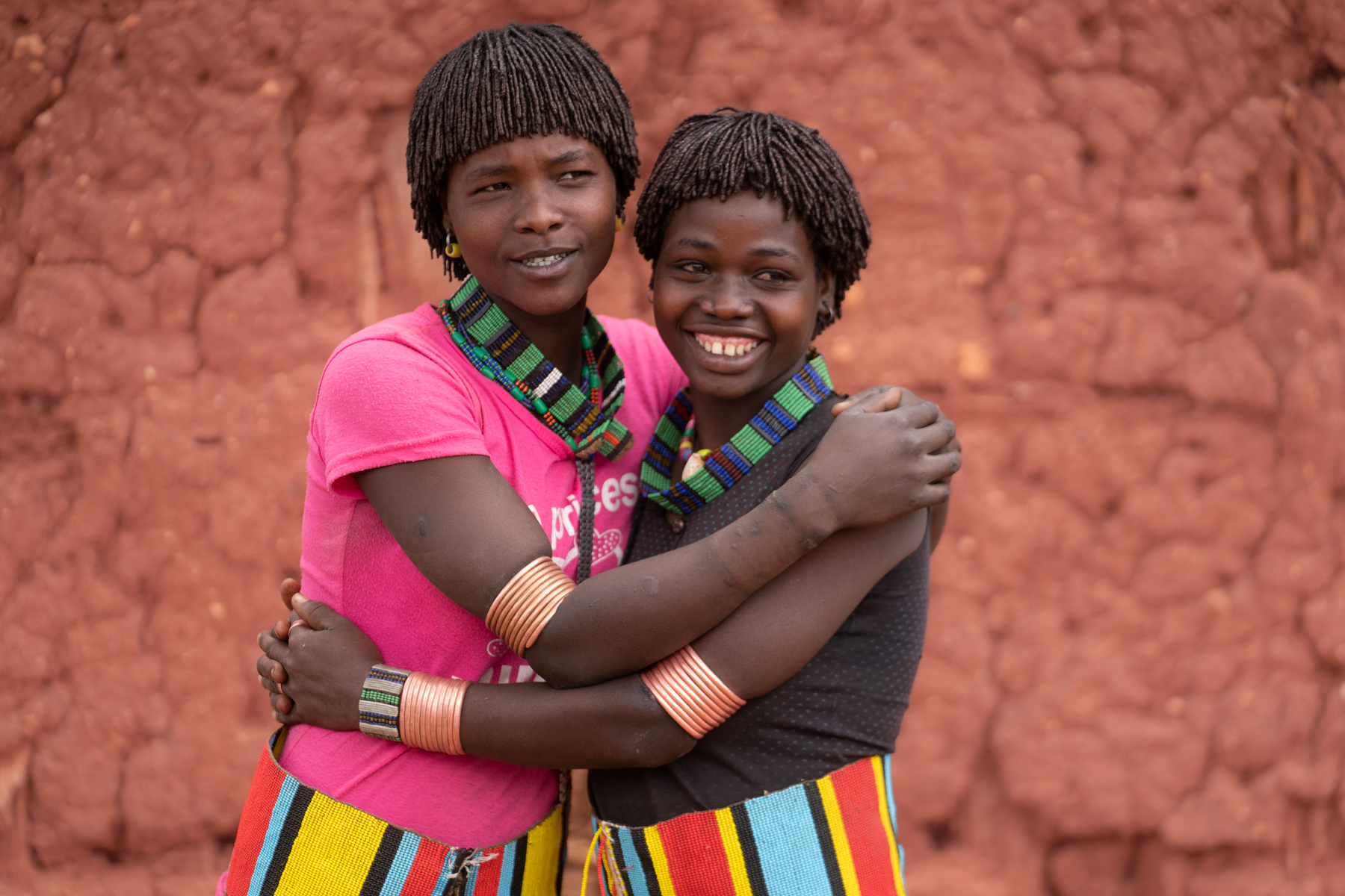 Benna best friends embrace and giggle in Alduba market (image by Inger Vandyke)