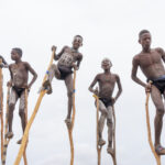 A group of young Benna boys showing off their strength and stilt walking prowess (image by Inger Vandyke)
