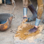 Dassanech men preparing yellow ochre to paint their bodies with in preparation for Dimi (image by Inger Vandyke)