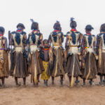 A young Dassanech girl surrounded by the women who have gone before her during Dimi, the Dassanech initiation of young women (image by Inger Vandyke)