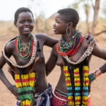 Young Hamer best friends smiling and exchanging laughs during our visit to their village (image by Inger Vandyke)