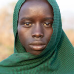 Portrait of a young Suri herder at sunrise in his cattle camp (image by Inger Vandyke)