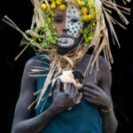 Suri woman with her lip disc and tiny puppy (image by Inger Vandyke)