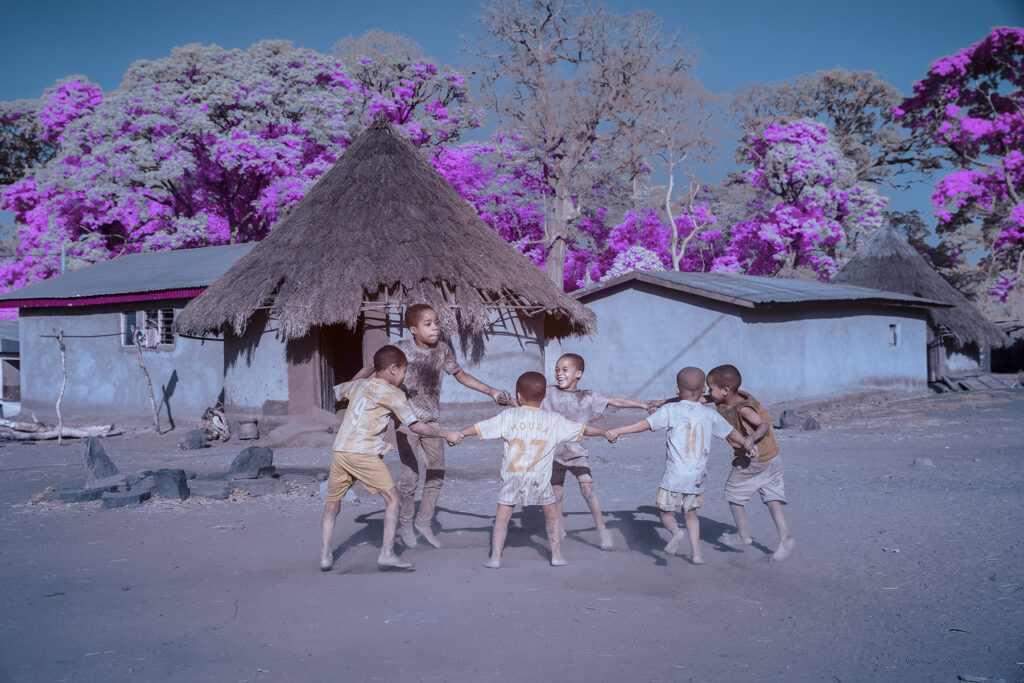 A group of children hold hands to dance ahead of the Godoufou ceremony being performed in their village (image by Rosalie Wang)