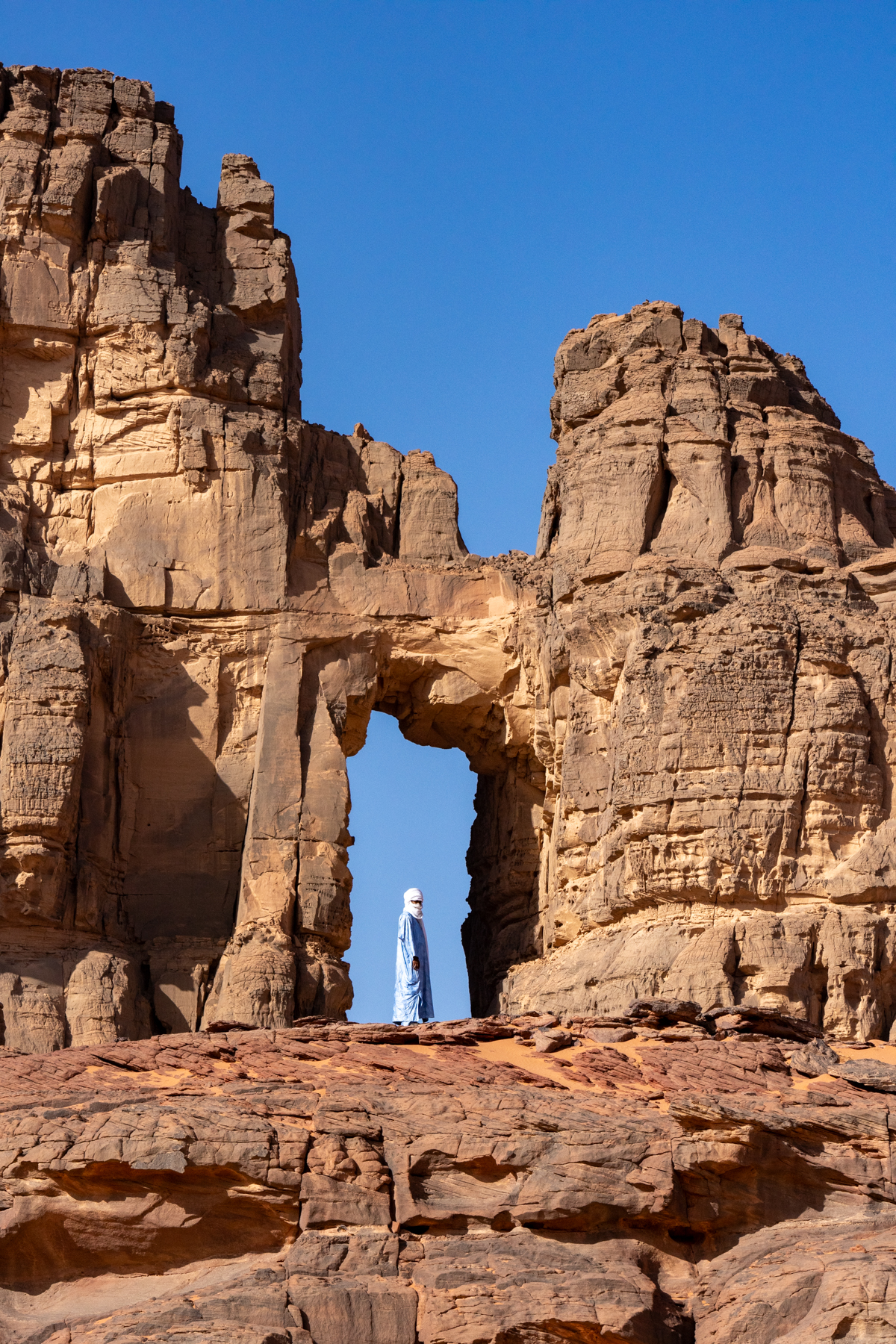 Our guide standing in the spectacular Timjadawin, the Cathedral of Tadrart Rouge (image by Inger Vandyke)