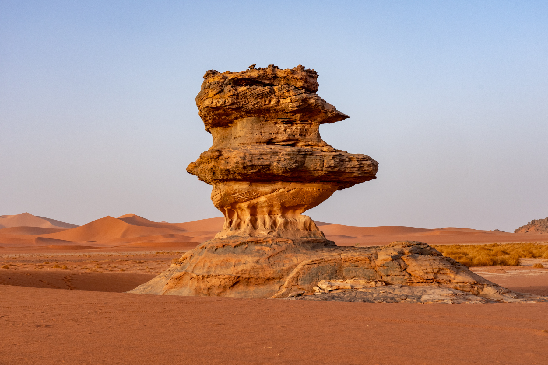 Dotted around Tadrart Rouge is countless wind and water eroded rock pillars. Even this one has an engraving of an elephant under its largest layer (image by Inger Vandyke)