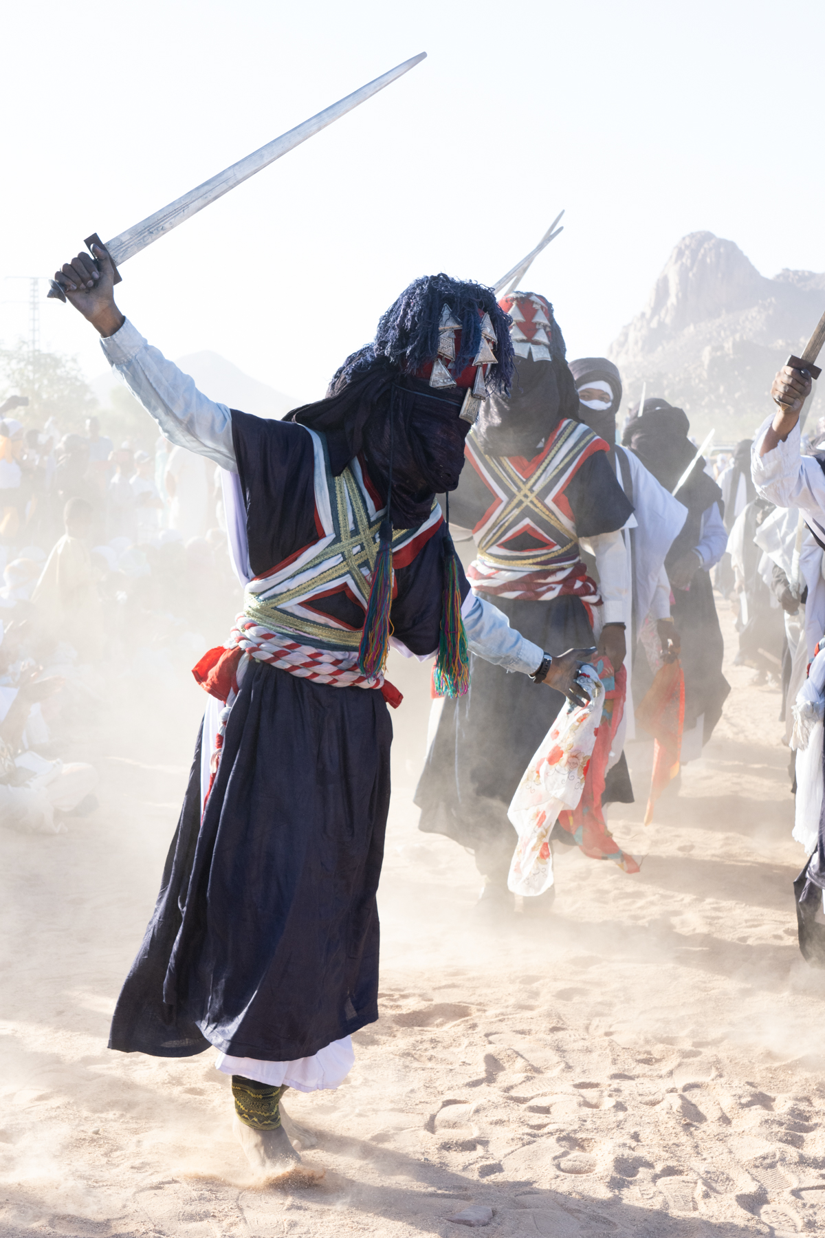 Tuareg men celebrating Sabiba waving their traditional Takouba swords in the air (image by Inger Vandyke)