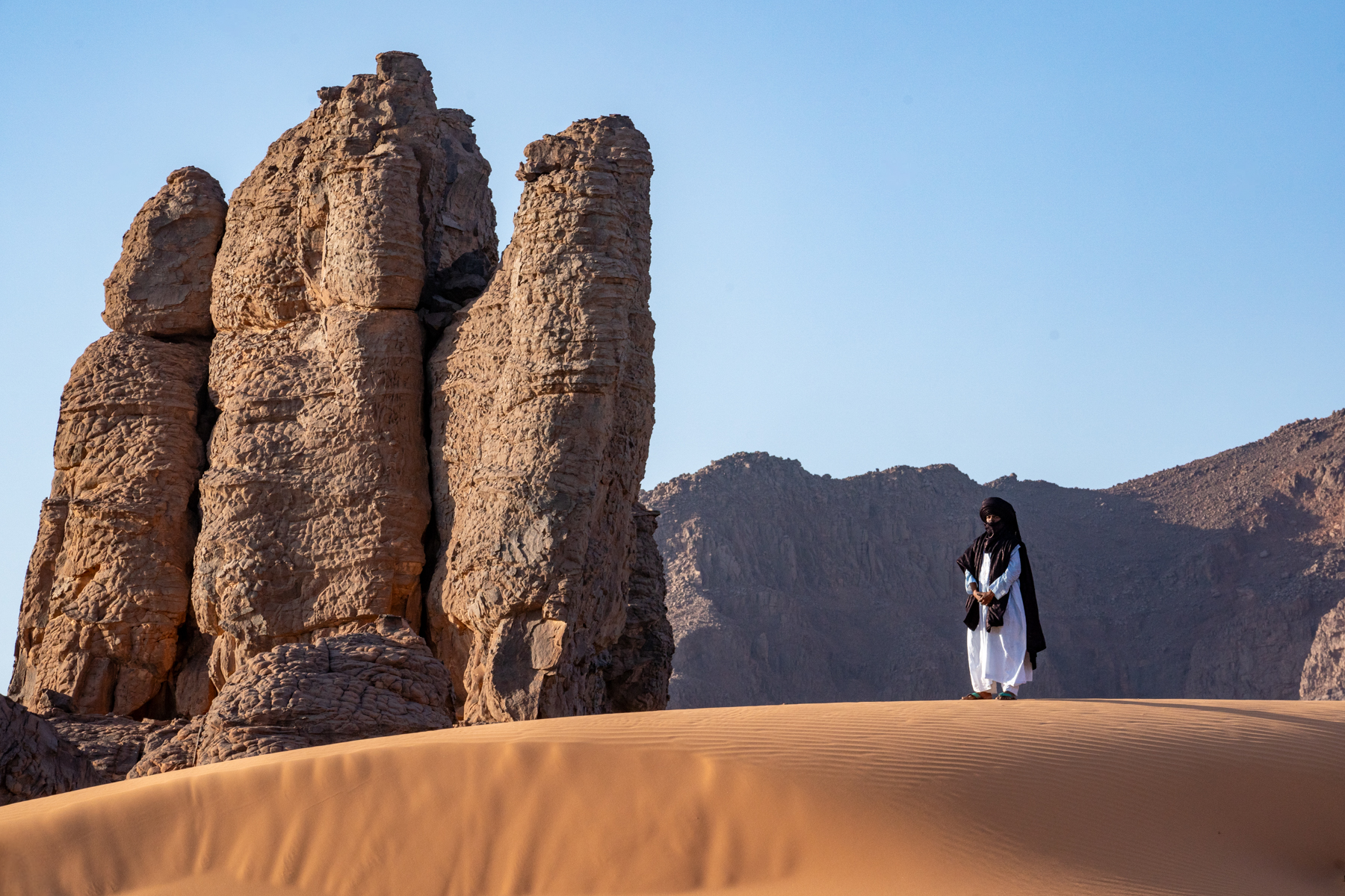 A Tuareg man adorns a spectacular corner of the Sahara close to the town of Djanet in southern Algeria (image by Inger Vandyke)