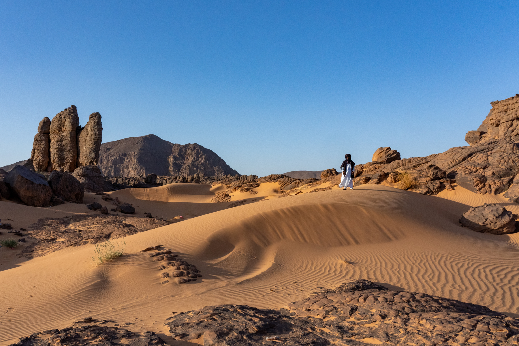 A Tuareg man dressed in a flowing Gandara and Tagelmoust for a private shoot in the desert near Djanet (image by Inger Vandyke)