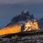 The first rays of sunrise light up the granite face of part of the Paine Massif, Patagonia (image by Virginia Wilde)