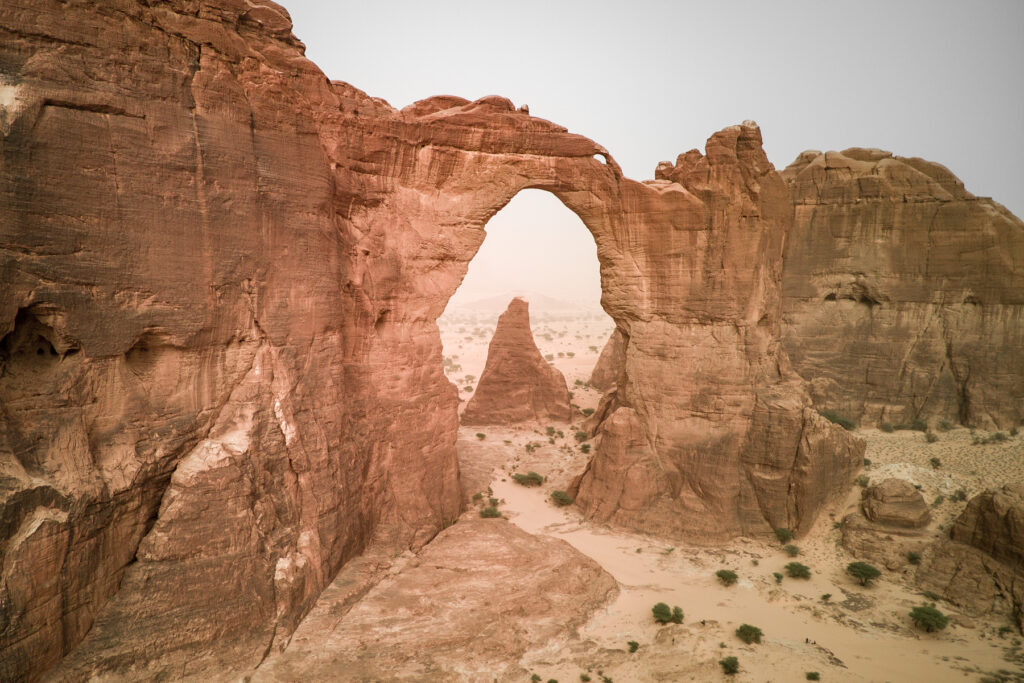 Drone's eye view of the arch of Aloba, the tallest rock arch in the world. At the base through the arch is our expedition vehicles (image by Inger Vandyke)