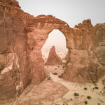 Drone's eye view of the arch of Aloba, the tallest rock arch in the world. At the base through the arch is our expedition vehicles (image by Inger Vandyke)