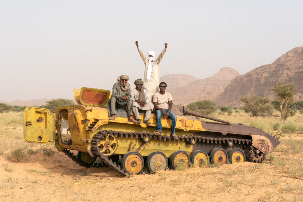 Our Chadian expedition team on the rusting remains of a Libyan tank in the Ennedi (image by Inger Vandyke)