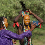 Young Wodaabe men help each other to prepare for the Gerewol (image by Inger Vandyke)