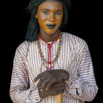A beautiful Wodaabe boy with his face half-painted in preparation for the Gerewol (image by Inger Vandyke)