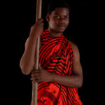 Portrait of a young man holding a ceremonial umbrella at an Ashanti funeral (image by Inger Vandyke)