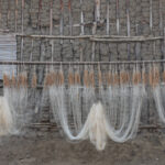 Fishing nets hanging to dry at a remote community on the border of Benin and Nigeria (image by Inger Vandyke)
