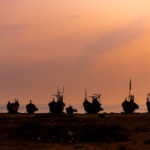 The line up of fishing pirogues at sunrise in Elmina (image by Inger Vandyke)