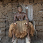 A Koku dancer pauses to sit on the Koku shrine which will give him the energy to continue with the ceremony (image by Inger Vandyke)