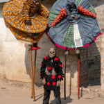 Kpodji Guegue stilt dancers taking a break with their ghoulish guardian (image by Inger Vandyke)