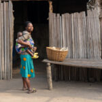 A mother cradles her young baby in a Beninese fishing community (image by Inger Vandyke)