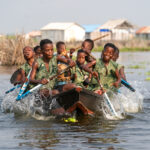 Tofinu boys playing in their canoe on the waters of Ganvie (image by Inger Vandyke)