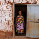 Portrait of a twins priestess in the doorway of her home in remote Benin (image by Inger Vandyke)