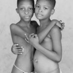 A black and white portrait of two young Krobo girls preparing for Dipo (image by Inger Vandyke)