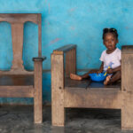 A young girl eats her breakfast at the palace of King Suorwu in Somanya, Ghana (image by Inger Vandyke)