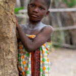 A young girl watches a ceremony of voodoo adepts in remote Benin (image by Inger Vandyke)