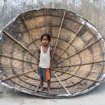 A young boy inside a rice drying topa (image by Inger Vandyke)