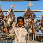 A young boy in the fish drying area of Bangladesh (image by Inger Vandyke)