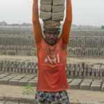 Adult men are tasked with carrying loads of 12 bricks to the kiln! (image by Inger Vandyke)