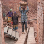 Men carrying bricks out of a brick pit (image by Inger Vandyke)