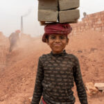 A young boy carrying bricks. Child labour is an issue in Bangladesh and although children carry lighter loads, they still work very hard! (image by Inger Vandyke)