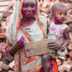 Portrait of a brick carrying woman and her baby. The pink pain was given by the supervisor to the workers to help them celebrate making their quota (image by Inger Vandyke)
