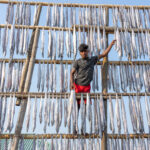 Young man working with dried fish in Bangladesh (image by Inger Vandyke)