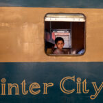 Portrait of a young boy on the older Inter City carriages of Kamalapur Railway Station in Dhaka (image by Inger Vandyke)