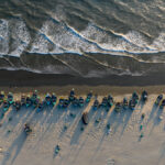 A line of pretty Moonboats sit waiting for action at the high tide mark (image by Inger Vandyke)
