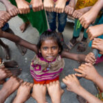 A circle of children in a rice drying courtyard (image by Inger Vandyke)