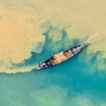 Sand mining boat on a green river (image by Inger Vandyke)