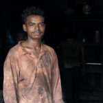 A young man working in the metal recycling part of Bangladesh's ship breaking yards (image by Inger Vandyke)