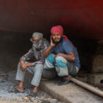 Ship workers taking a break from painting a hull (image by Inger Vandyke)
