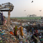 Women sort through newly arrived rubbish, looking for recycling materials (image by Inger Vandyke)