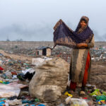 A waste picking woman covers herself with a shawl to stay warm at sunrise (image by Inger Vandyke)