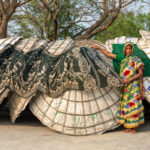 A woman lies her clothes out to dry on top of rice drying topas (image by Inger Vandyke)