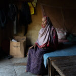 An elderly woman takes a break after cleaning the floor of a yoghurt factory (image by Inger Vandyke)